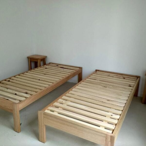 Dos camas individuales con estructura de tono madera y base de listones