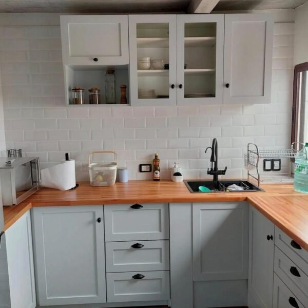 Cocina en esquina con frentes grises, alacenas y mesada de tono madera