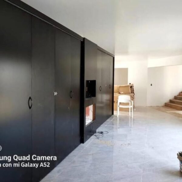 Cocina con grandes puertas oscuras cerradas e integrada al ambiente